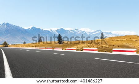 empty asphalt road near snow mountains in new zealand