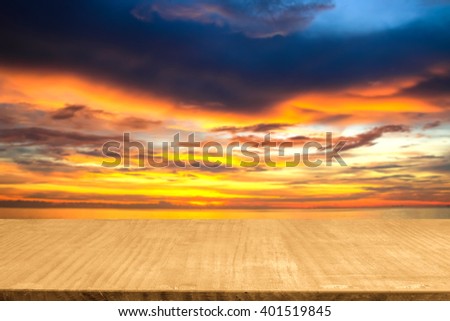 Empty top wooden table with blurred colorful cloud and sunset background.