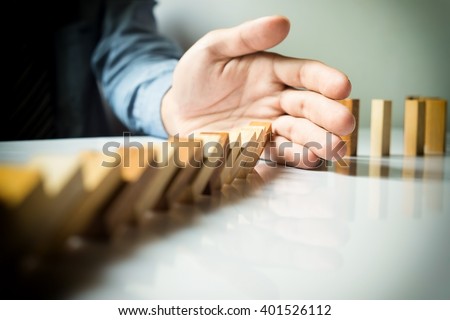 businessman hand stop dominoes continuous toppled or risk with copyspace Royalty-Free Stock Photo #401526112