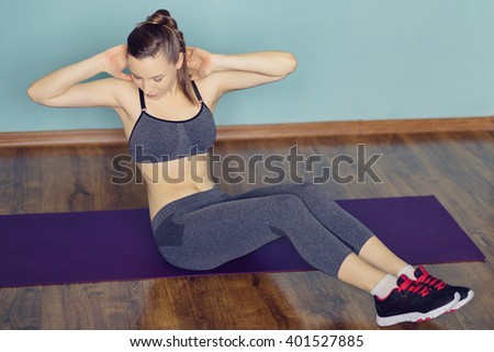 Young woman in sportswear doing sport at home