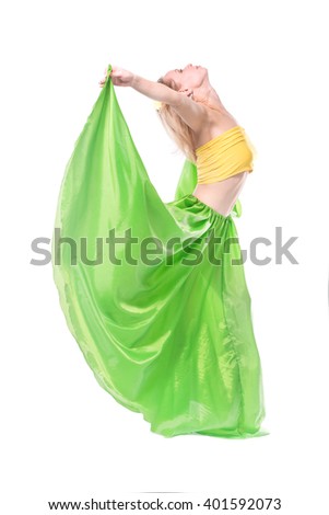 Beautiful young blonde girl in a yellow top, a long green skirt and a hairpin with a flower on her head dancing