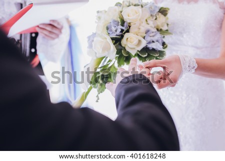 She wears a ring on his finger at the wedding, closeup