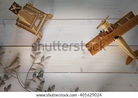 top view on white wood table. the edges are wooden airplane, model of the Eiffel tower and wrought-iron bird on a branch.