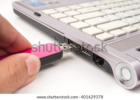 USB Pink flash drive stick being connected to computer, selective focus