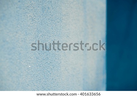 Pale light blue and dark blue plastered wall surface texture close up details with shallow depth of field as background image