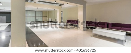 White hallway with marble floor and purple sofas on modern new university