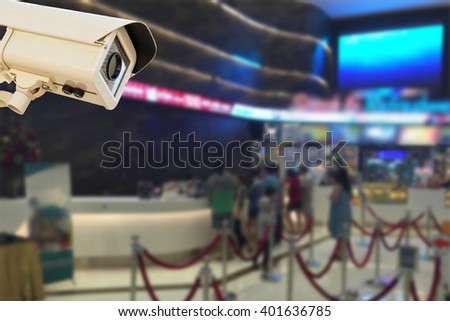 The CCTV Security Camera operating in center sale ticket and food for cinema blur background.