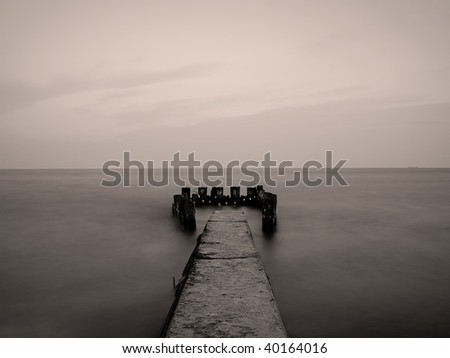 sea view with old pier at sunset