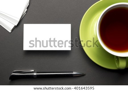 Business card blank over coffee cup and pen at office table. Corporate stationery branding mock-up
