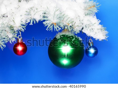 Christmas and New Year decoration- balls with  snow-covered fir branches .On blue background