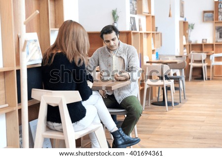Young couple ignoring the environment being addicted to social media. Conceptual image with people pretending that are always using phones or tablets in normal life.
