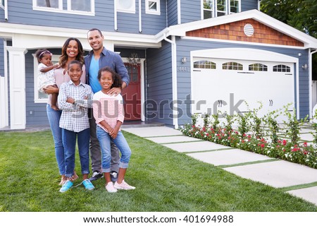 Happy black family standing outside their house Royalty-Free Stock Photo #401694988