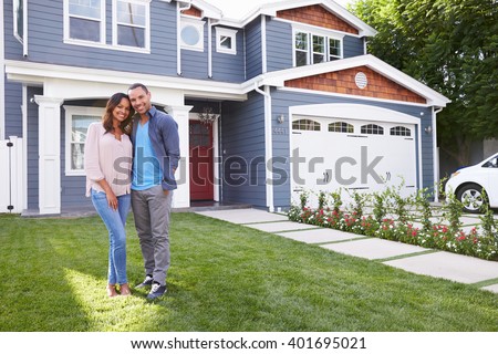Happy black couple standing outside their house Royalty-Free Stock Photo #401695021