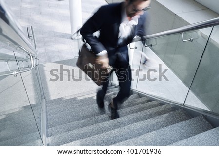 Businessman running up the stair, blurred motion Royalty-Free Stock Photo #401701936