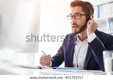 Tech support manager in headset consulting a client Royalty-Free Stock Photo #401701957