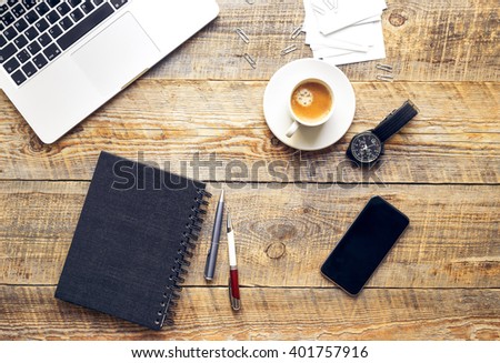 Working place, wooden table with laptop, phone and coffe cup