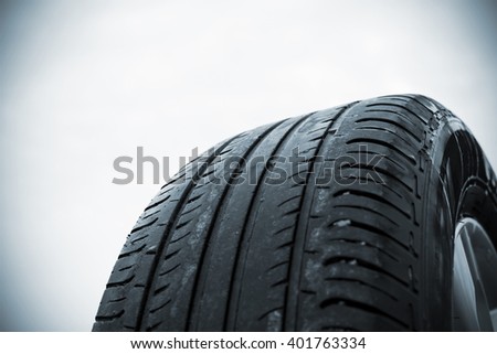 Very worn summer tire photographed in close-up in Finland. Focal point is the center of the photo. Front and back of the photograph out of focus. Image includes a black and white effect.