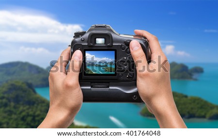 Hands holding the camera which taking photo of Top view of Ang Thong National Marine Park with rainbow, Thailand