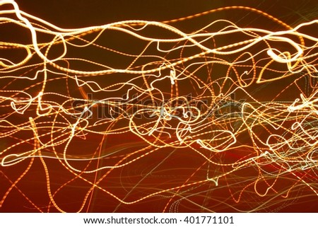 Electronic Spaghetti, Abstract Long Time Exposure out Side Window of Car Traveling at Night of Passing Street Lights Creating Yellow Streaks with a Swash of Red Indicating the Road Below