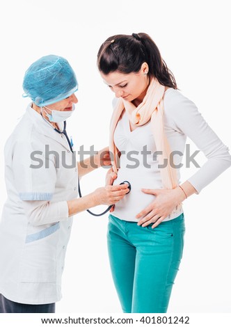 Senior doctor is examining young pregnant female using a stethoscope - isolated on white background