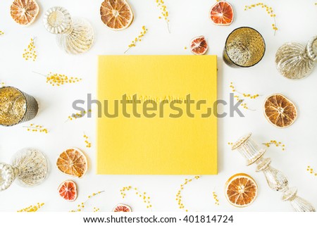 yellow wedding photo album, dry oranges, candlesticks, branches of mimosa isolated on white background. flat lay, overhead view