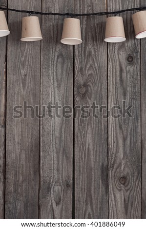 garland of paper cups hangs on wooden boards