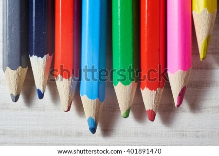Stack of colored pencils on white table. Studio shot
