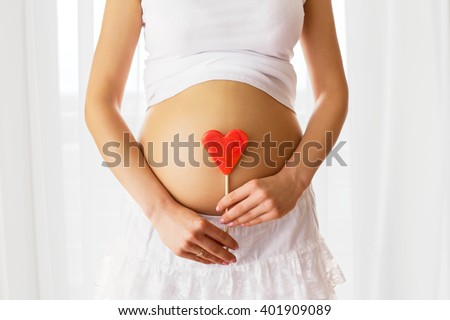  Picture of pregnant woman holding heart sign 