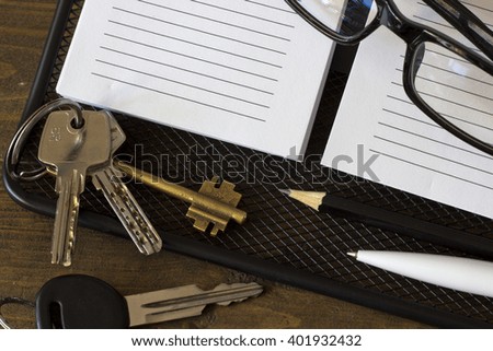 glasses and a lot of keys from the house on the notebook top view