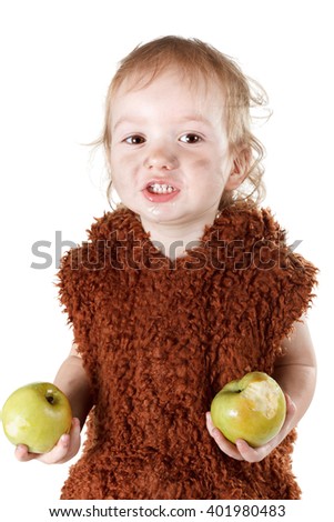 Little funny Neanderthal boy in a suit with a dirty face eating an apple. Humorous concept ancient caveman. Isolated on white.