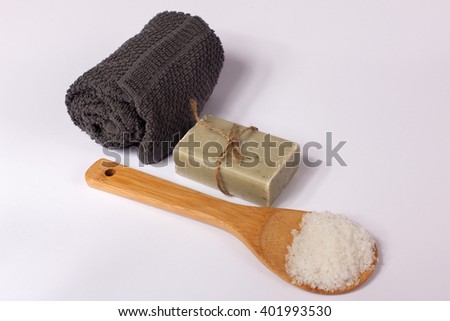 Natural soap, towel and wood spoon with salt on white background