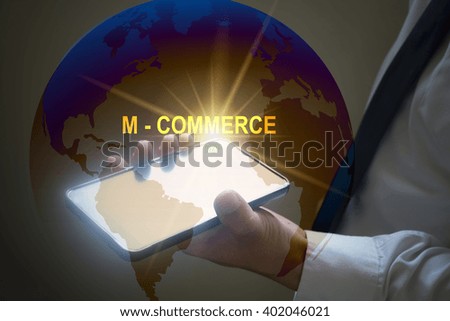businessman holding mobile phone with M COMMERCE  text on virtual screen. Internet concept.
