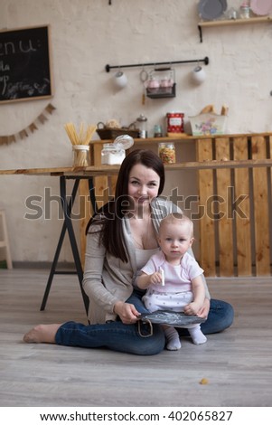 Young mother and toddler daughter  drawing  black board and chalk, lifestyle real interior