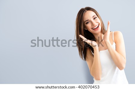 young woman showing smile, in casual smart clothing, with copyspace for slogan or text message Royalty-Free Stock Photo #402070453