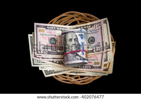 Basket with dollar isolated on black