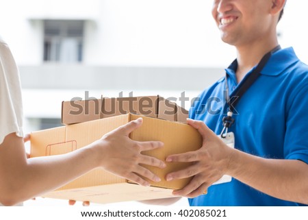Woman hand accepting a delivery of boxes from deliveryman Royalty-Free Stock Photo #402085021