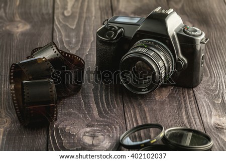 Old film photo camera with camera accessories on wooden rustic background Royalty-Free Stock Photo #402102037