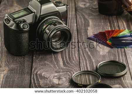 Old film photo camera with camera accessories on wooden rustic background  Royalty-Free Stock Photo #402102058