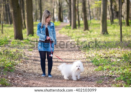 Beauty woman and her dog in the park a spring day