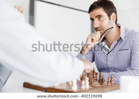 Portrait of two young man playing chess 