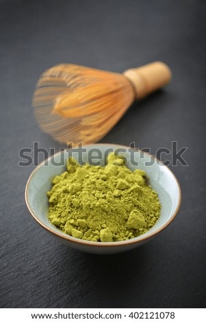 Organic Green Matcha Tea in a small cup over slate background