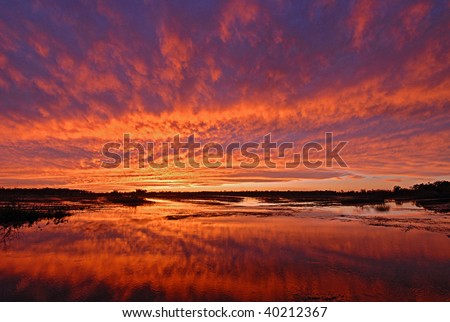 Bright orange sunset sky reflect in marsh wetland in Louisiana Royalty-Free Stock Photo #40212367