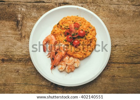 classic italian risotto with shrimps and prawns on a wooden background