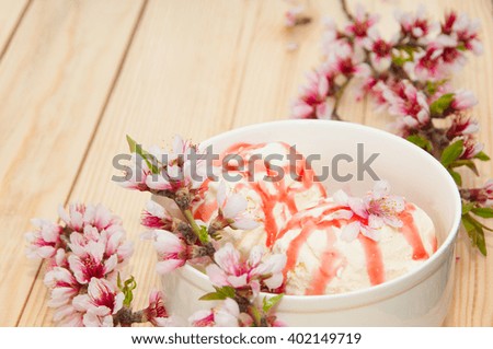 Vanilla ice cream with cherry on wooden background