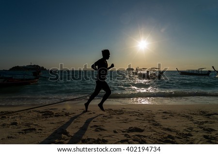 silhouette of running at sunrise time over the sea beach with lens flare
