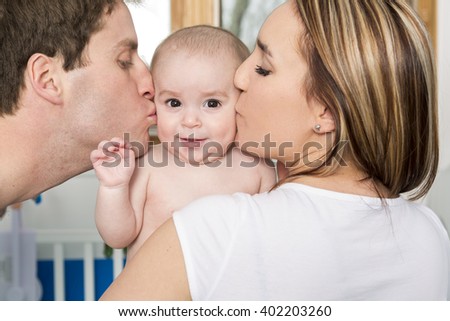 A Closeup portrait of young parents kissing beautiful newborn son