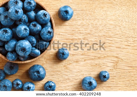 Healthy blueberries in bowl on wooden background. Close up, top view, high resolution product. Harvest Concept