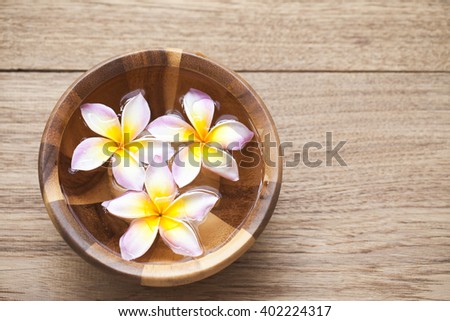 Beautiful flower in a bowl on wood background for spa shop.