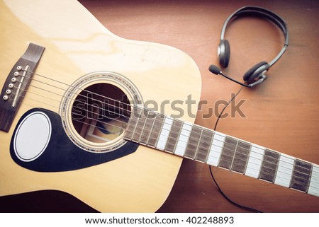 A guitar and earphone , close up,Vintage style photo with custom white balance, color filters, soft focus effect, and some fine film grain added