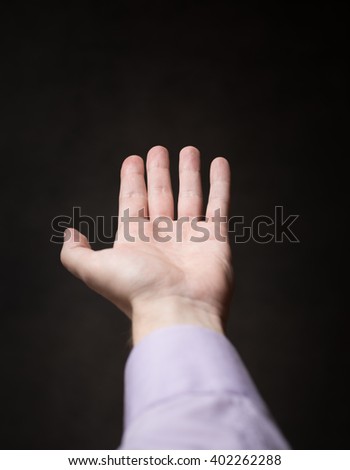 Hand of a man on a dark background.